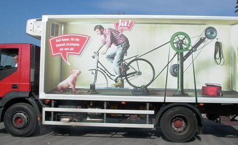 funny truck wrap man talking to pig while riding bike that powers truck